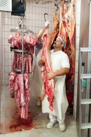 Der Metzger holt eine Schweinehälfte aus der Kühlkammer